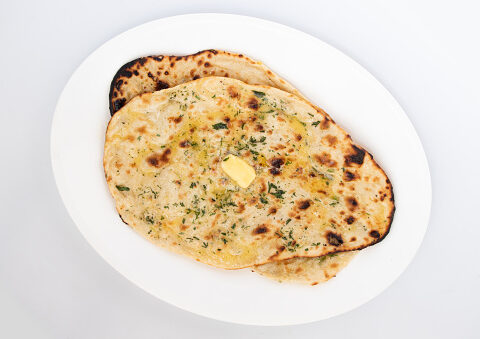 Indian Tandoori Naan Bread Also Called Amritsari Tanduri Nan Kulcha Bread Cooked In Hot Oven Tandoor Is Popular Flatbread Enjoyed In North And South India. Isolated On White Background With Copy Space