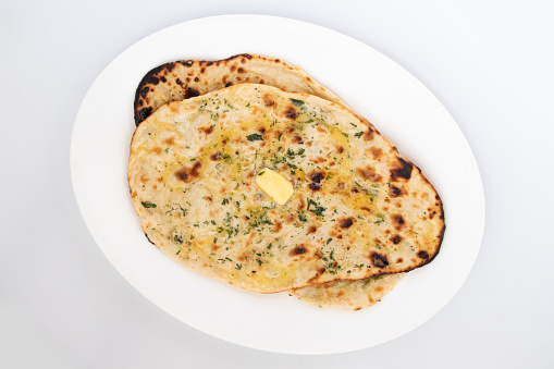 Indian Tandoori Naan Bread Also Called Amritsari Tanduri Nan Kulcha Bread Cooked In Hot Oven Tandoor Is Popular Flatbread Enjoyed In North And South India. Isolated On White Background With Copy Space